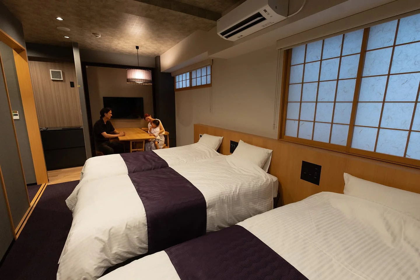 窓際にベッドを配した明るいホテル客室の全景